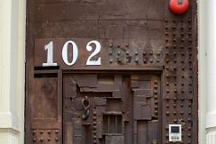16-2 Steel Sculpture Door at 102 Greene St Designed by William Tarr - The hook Is The Door Knocker, the Barred Square Opens From The Inside In SoHo New York City
